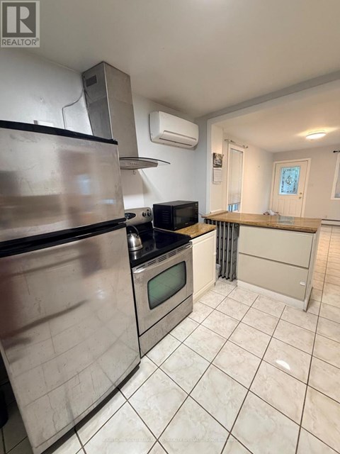 A kitchen with a stainless steel refrigerator, microwave, and oven.