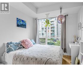A bedroom with a large bed and a painting on the wall.