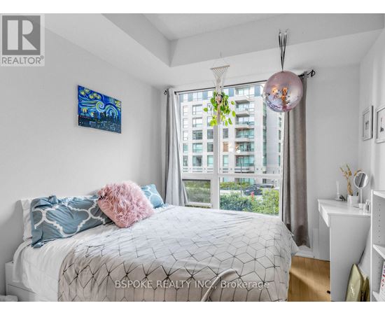 A bedroom with a large bed and a painting on the wall.
