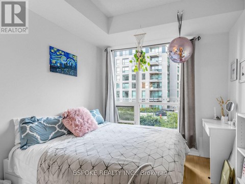 A bedroom with a large bed and a painting on the wall.
