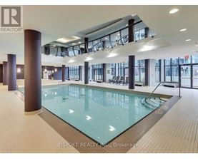 A large indoor swimming pool with a glass bottom and a tiled floor.