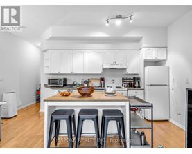 A white kitchen with a table and chairs.