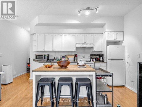 A white kitchen with a table and chairs.