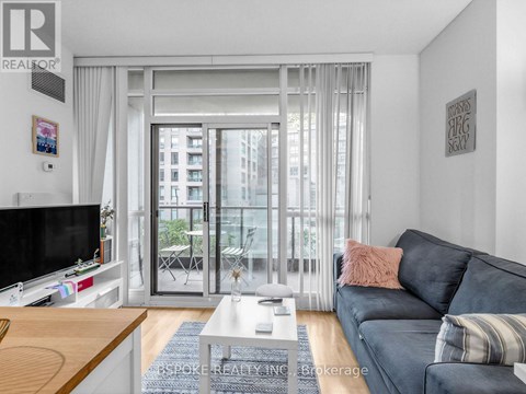 A living room with a grey couch and a flat screen TV.