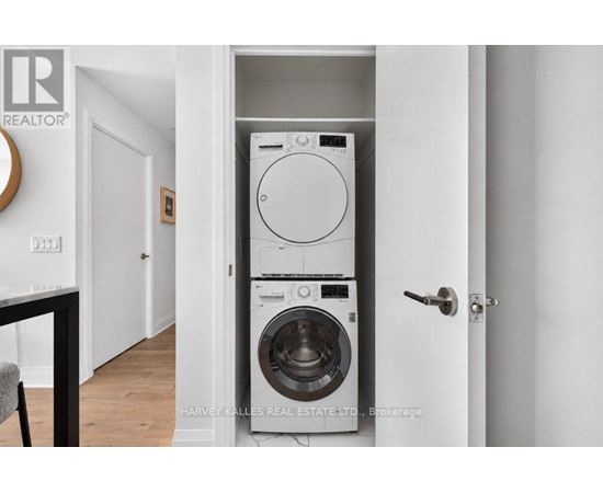 A white washer and dryer are stacked on top of each other in a small space.
