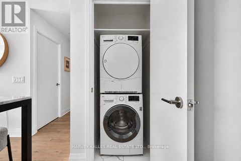 A white washer and dryer are stacked on top of each other in a small space.