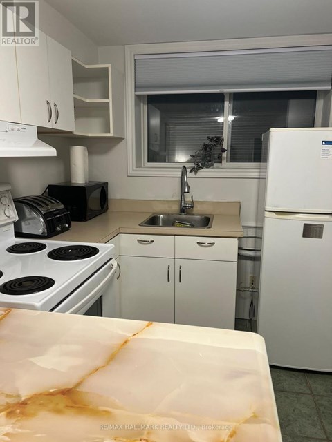 A kitchen with white appliances and cabinets.