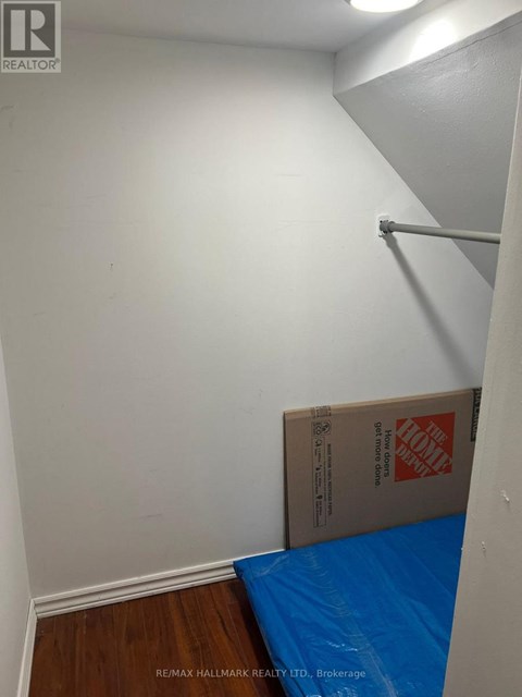 A room with a white wall and a blue tarp on the floor.