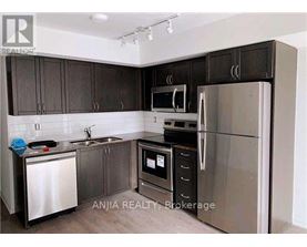 A kitchen with dark brown cabinets and stainless steel appliances.