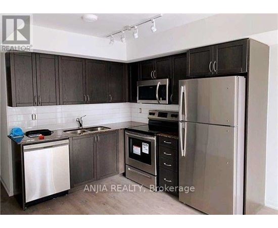 A kitchen with dark brown cabinets and stainless steel appliances.