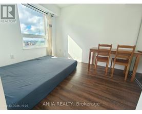 A bedroom with a bed, desk, and chair.