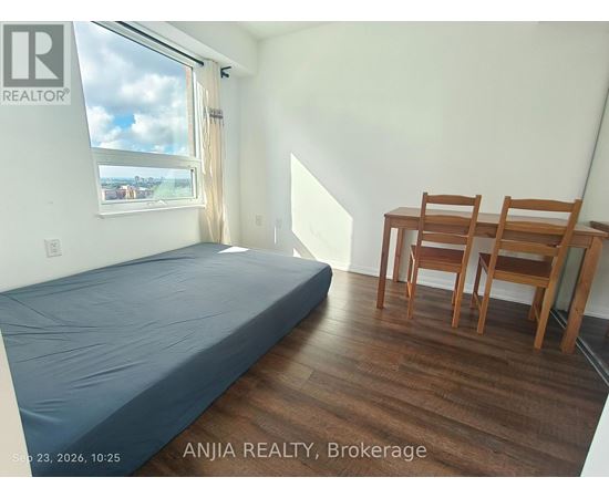 A bedroom with a bed, desk, and chair.