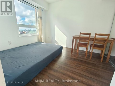 A bedroom with a bed, desk, and chair.