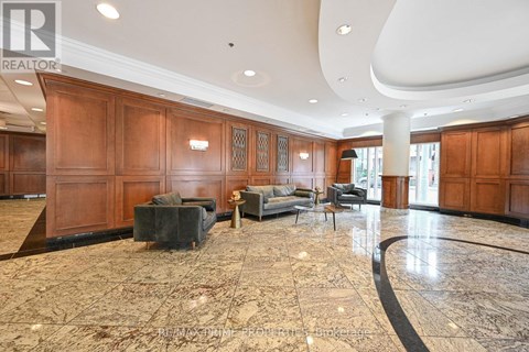 A spacious living room with wooden paneling and a marble floor.