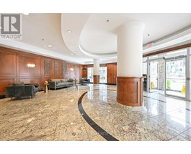 A large, open lobby with a marble floor and wooden furnishings.