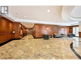 A spacious living room with a marble floor and wooden cabinets.
