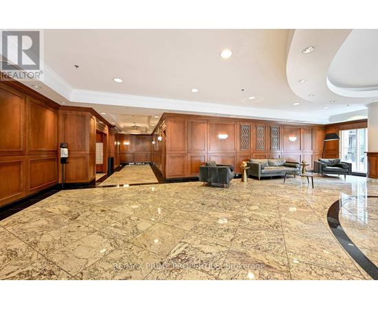 A spacious living room with a marble floor and wooden cabinets.