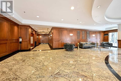 A spacious living room with a marble floor and wooden cabinets.