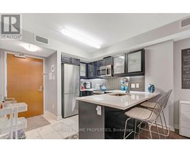 A kitchen with a sink, refrigerator, and a dining table.