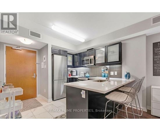 A kitchen with a sink, refrigerator, and a dining table.