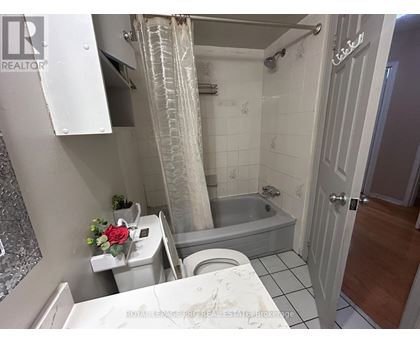 A bathroom with a white toilet, a bathtub, and a shower curtain.