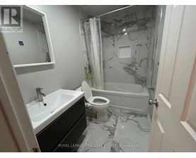 A bathroom with a marble floor and a toilet.