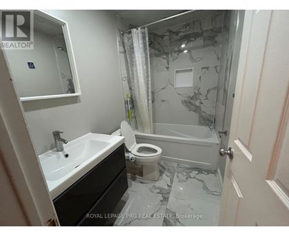A bathroom with a marble floor and a toilet.
