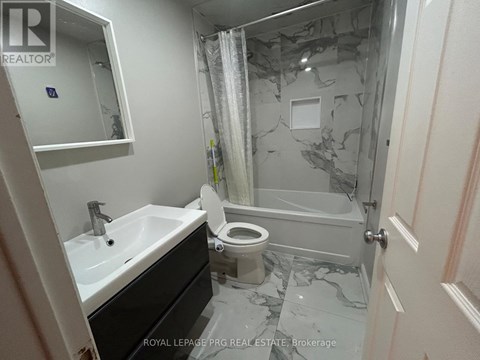 A bathroom with a marble floor and a toilet.