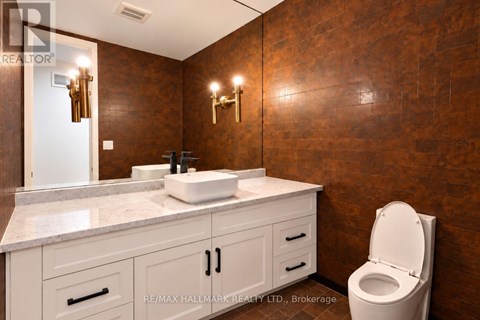 A bathroom with a brown wall and a white toilet.