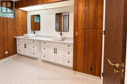 A bathroom with a sink, mirror, and wooden door.