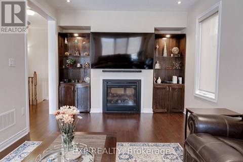 A living room with a fireplace and a vase of flowers on the coffee table.