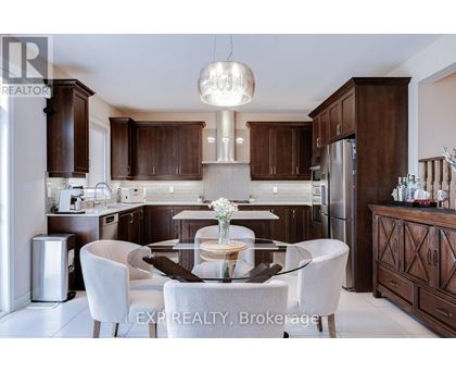 A modern kitchen with dark wood cabinets and a glass table with four chairs.