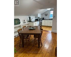 A dining room with a wooden table and chairs.