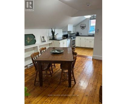 A dining room with a wooden table and chairs.