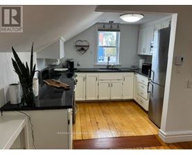 A kitchen with white cabinets and a black counter top.