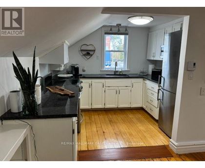 A kitchen with white cabinets and a black counter top.