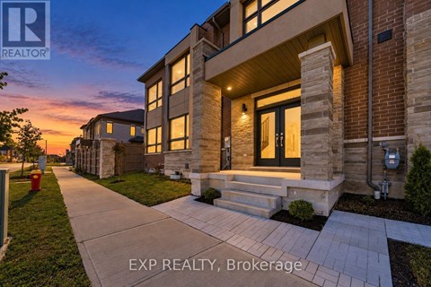 A house with a walkway in front of it at dusk.