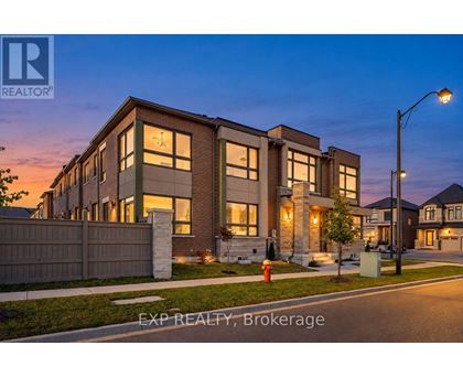 A modern house with a well-lit front yard at dusk.
