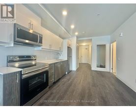 A modern kitchen with stainless steel appliances and wooden cabinets.