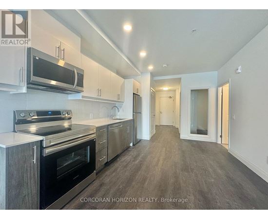 A modern kitchen with stainless steel appliances and wooden cabinets.