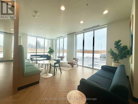 A living room with a black couch and a wooden floor.