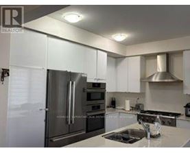 A modern kitchen with stainless steel appliances and white cabinets.