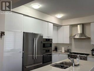 A modern kitchen with stainless steel appliances and white cabinets.