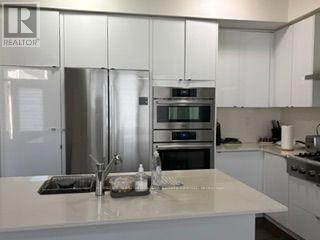 A kitchen with a white counter top and stainless steel appliances.
