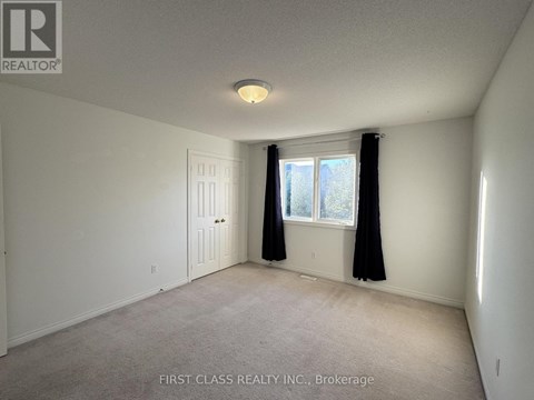 A room with a carpet floor and a window with black curtains.