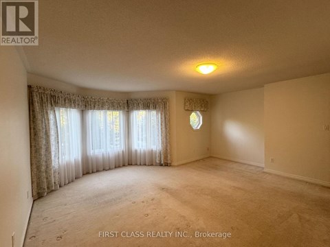 A room with a window covered by curtains and a light on the ceiling.