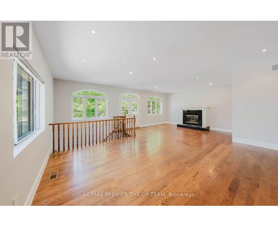 A spacious room with wooden floors and a fireplace.