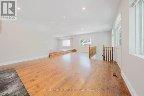 A spacious room with wooden flooring and white walls.