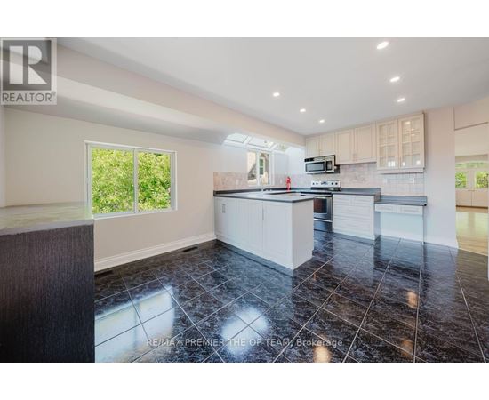 A kitchen with black tiles on the floor and a wooden counter top.
