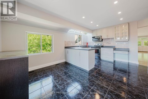 A kitchen with black tiles on the floor and a wooden counter top.
